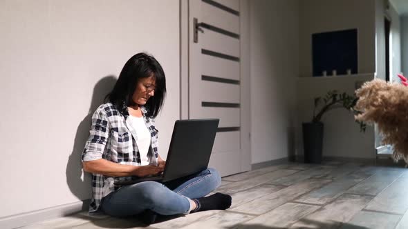 Mature Female typing on the computer for remote working