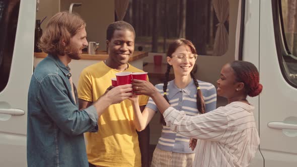 Diverse Friends Cheering with Red Cups at Campsite