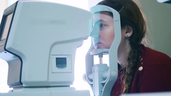 A Lady is Having Her Eyes Examined By a Medical Device