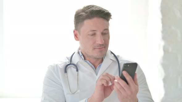 Portrait of Male Doctor Browsing Internet on Smartphone