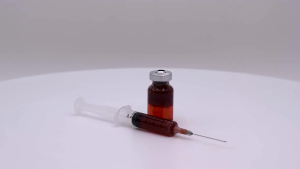 Vaccine bottle with red solution with syringe