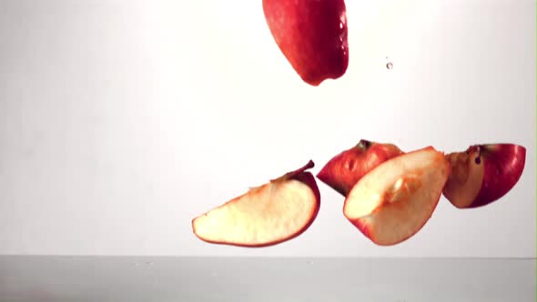 Super Slow Motion Pieces of Ripe Apple Fall Into the Water with Splashes