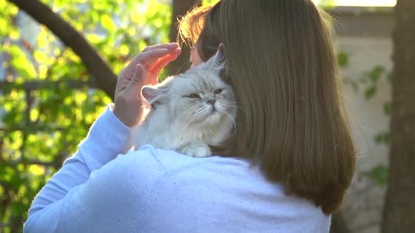 Asian Woman Holding Her Cat In The Light Of Sunset