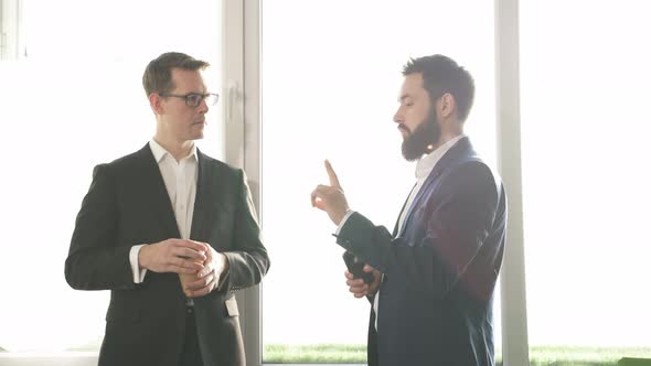 Friendly Male Director Gives Instructions and Advice to His Employee During a Coffee Break