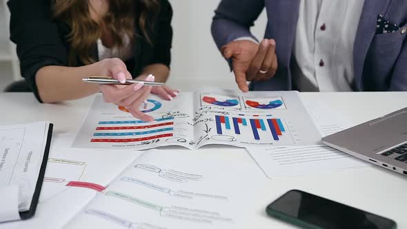 Office Workers which Discussing Financial Documents with Diagrams During Joint Work