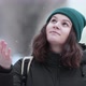A young woman catches snowflakes with her hand in a snowfall - VideoHive Item for Sale