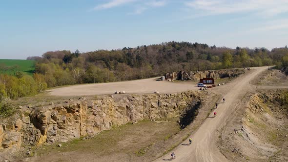 Aerial footage of sports cyclists climbing up a steep gravel road, drone stock footage