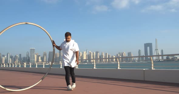 Young Athlete is Spinning a Big Wheel Around Himself Dubai Marina View