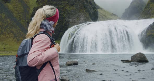 Iceland Woman with Backpack Enjoying Stjornarfoss Waterfall Near Kirkjubaejarklaustur