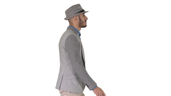 Casual arabic man in hat walking on white background.