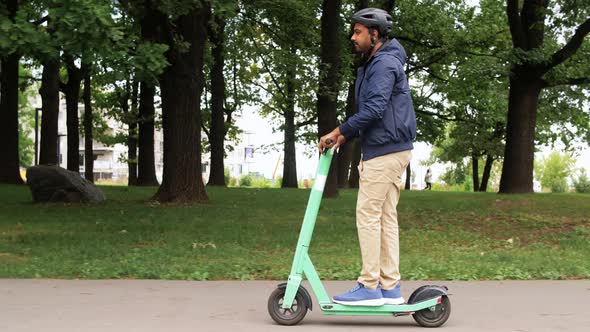 Man in Helmet Riding Electric Scooter on Street