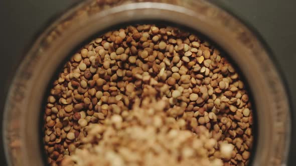 Brown Lentils Grains Pouring Into A Glass Jar