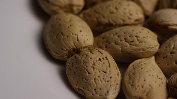 Cinematic, rotating shot of almonds on a white surface - ALMONDS