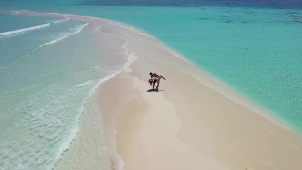 Loving couple dancing on sandy dune washed by turquoise seawater