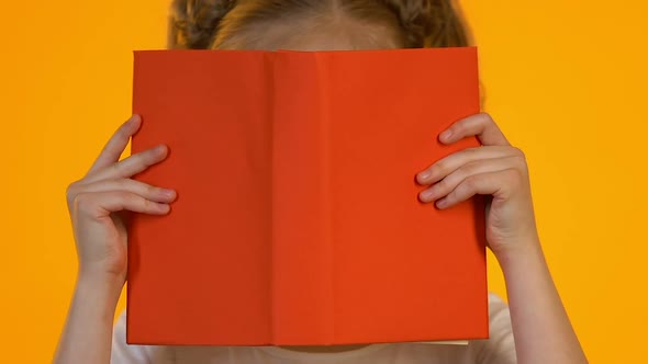 Little Smart Kid in Eyeglasses Reading Encyclopedia Shocked by Interesting Facts