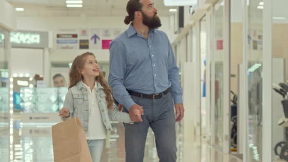 Loving Father Walking at Shopping Mall with His Adorable Little Daughter