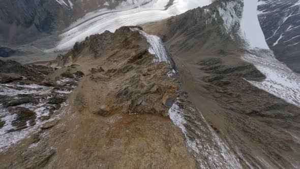 Aerial View Fast Dive Movement From Cliff Peak on Wide Stone Ridge Between Rocks