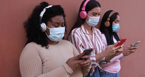 Young latin women wearing safety face mask while using smartphone