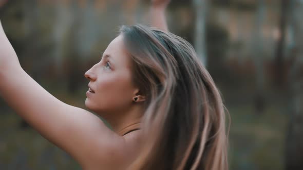 Mysterious Angelic Girl in White Black Dress Spinning in the Forest with Outstretched Hands