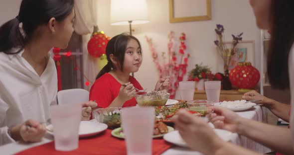 Happy Chinese Family Eating Dinner For Chinese New Year Celebrations Together At Home.