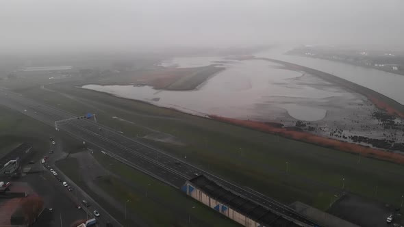 Traffic Along The A15 Motorway With Noord River During Low Tide In Netherlands. - aerial