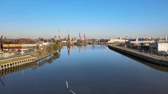 Aerial dolly in shot capturing the revitalize waterways from Matanza river with industrial port cran