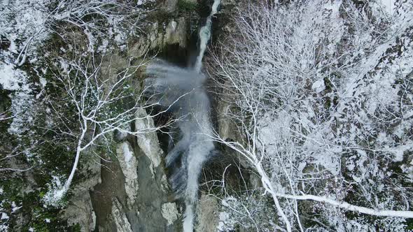 Waterfall Flowing From White Rocks Into a Lake in the Forest