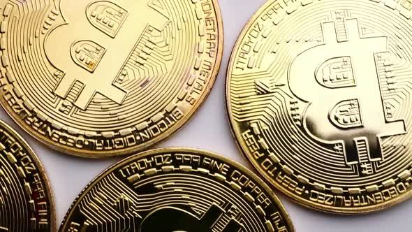 Close up of golden coins with bitcoin symbol background.