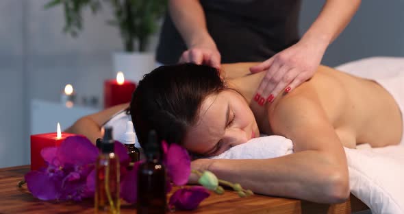A Woman is Given a Back Massage Closeup