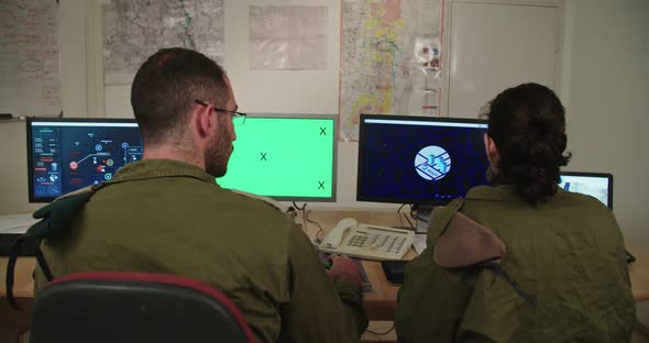 Israeli soldiers in a military command and control room looking at screens