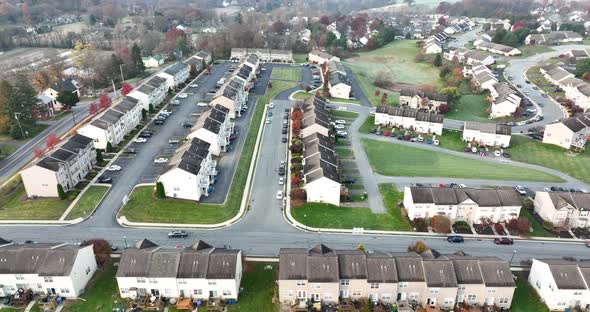 Aerial truck shot of townhouse homes in USA neighborhood in barren autumn fall landscape.