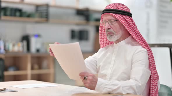 Senior Old Arab Businessman Reading Documents in Caf�