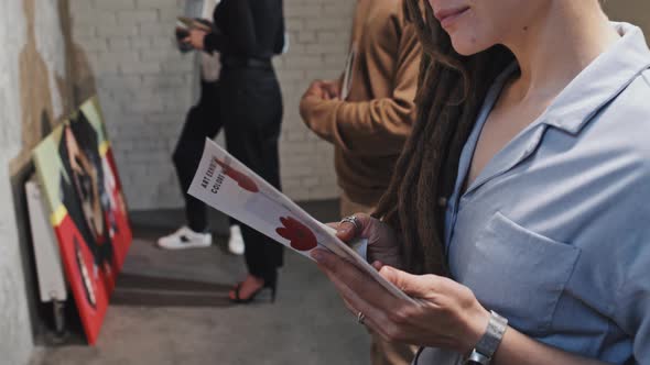 Girl Reading Brochure on Exhibition