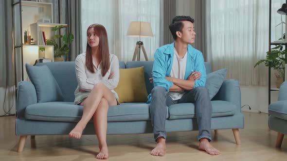 Sad Frustrated Young Asian Couple Being In Quarrel Sitting On Sofa In Living Room