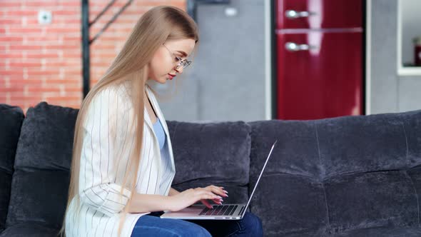 Confident Young Freelancer Girl Working Typing Text Using Laptop at Home Medium Shot