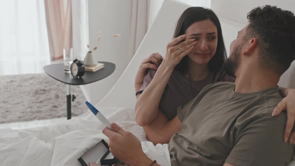 Young Happy Couple With Pregnancy Test In Bed