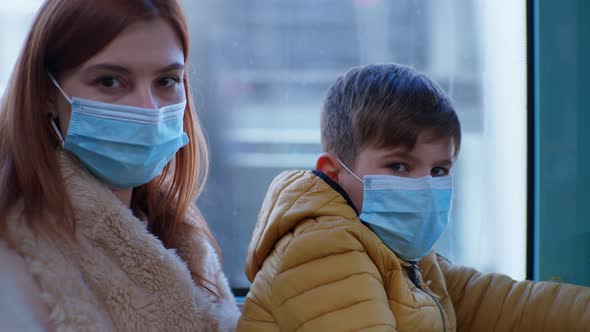 Mother with Male Child Wearing Medical Masks To Protect Against Coronavirus While Traveling on