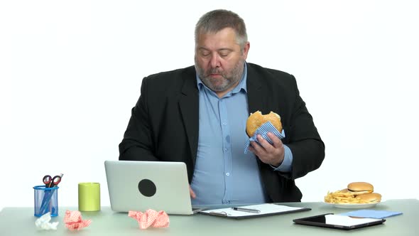 Overweight Businessman Eating Junk Food