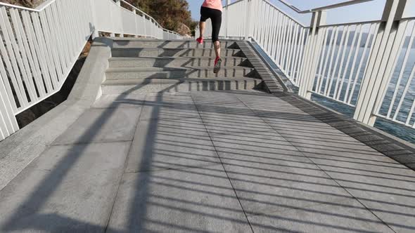 Fitness sports woman runner running on seaside trail, slow motion