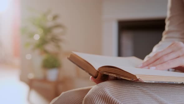 Woman Reads Book at Home. Hand Turning Pages of a Book