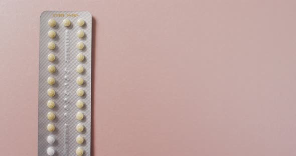 Video of close up of yellow tablets on pink background