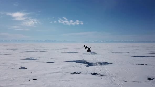 Aerial View Snowmobiles Ride on the Frozen Lake Baikal in Winter