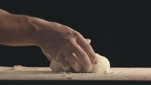 Male Hands Take Off a Piece of Baking Dough From Wooden Table Sprinkled with Flour