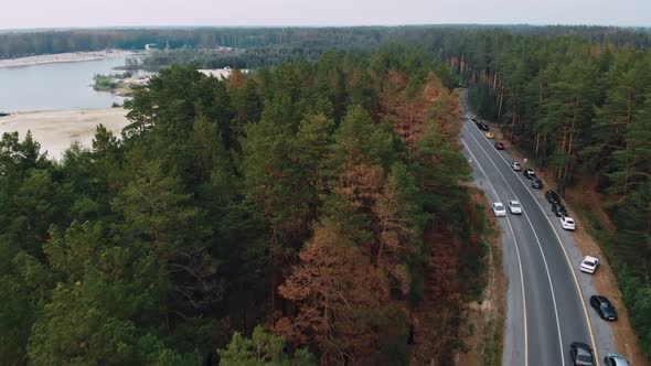 A Drone Flies Over the Road Along Which Vacationers Travel in Cars