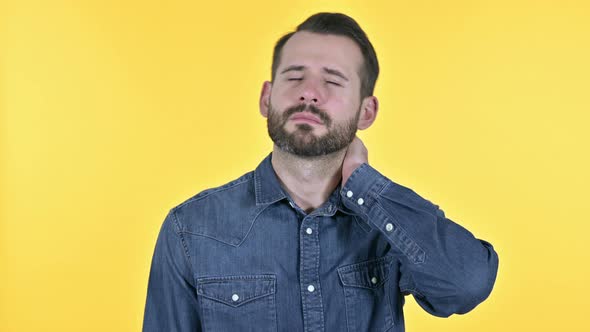 Tired Beard Young Man Having Neck Pain, Yellow Background