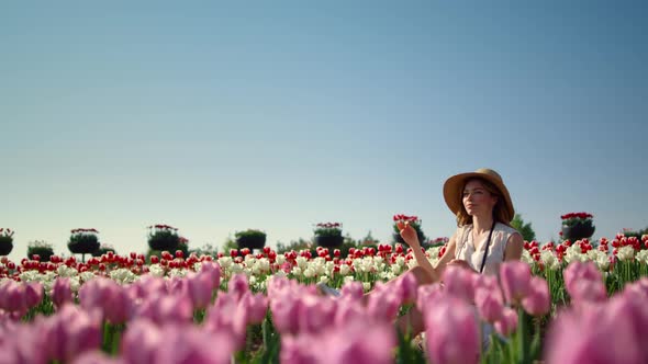 Young Gentle Woman in Hat Enjoying Sunlight in Blooming Floral Landscape