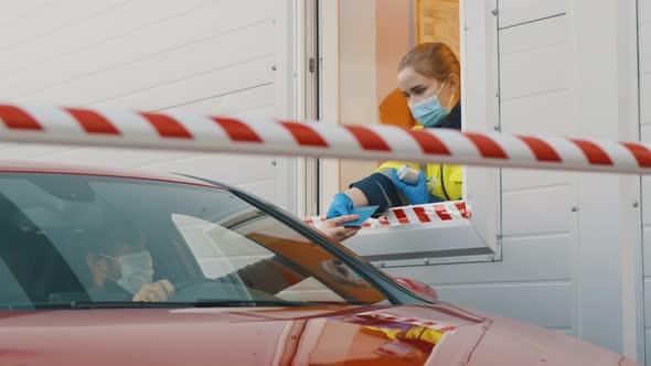 Driver Giving Passport To Worker in Booth for Passing Through Border at Checkpoint