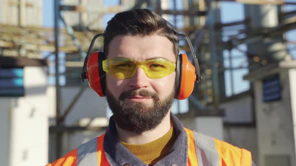 Portrait of Smiling Male Worker Wearing Safety Goggles and Hearing Protectors