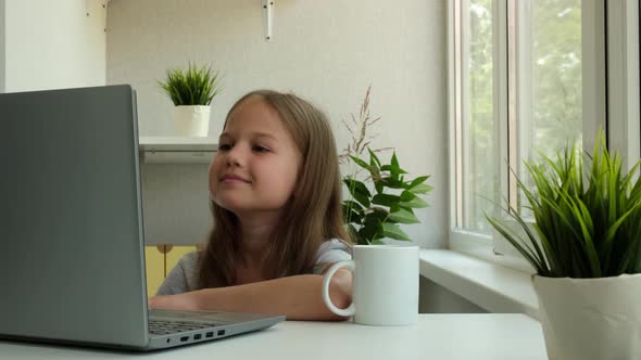 Little Girl is Using a Laptop and Study Online at Home