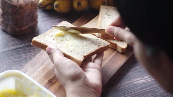 Slow Motion of Young Women Spreading Bread on Bread